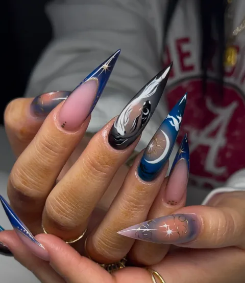 Long stiletto acrylic nails with hand-painted blue betta fish, moon, stars, and galaxy art by Leah